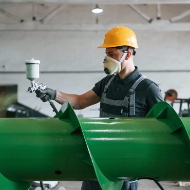 Painting details. Man in uniform is in workstation developing details of agriculture technique.